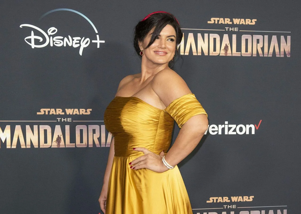 Gina Carano in yellow sexy dress with plus size showing her back at Disney stage in award ceremony
